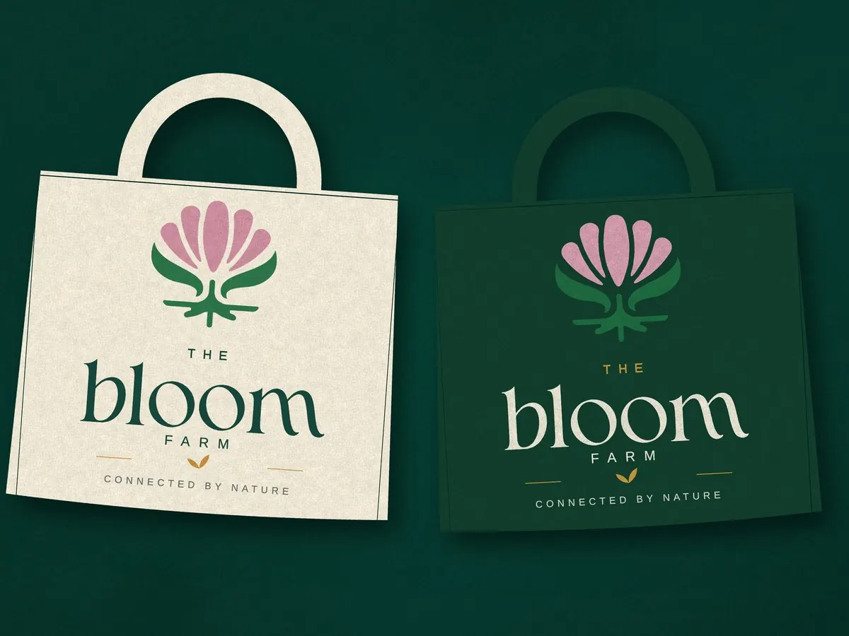 Two Bloom Farm shopping bags, one cream and one forest green, each with the Bloom logo.